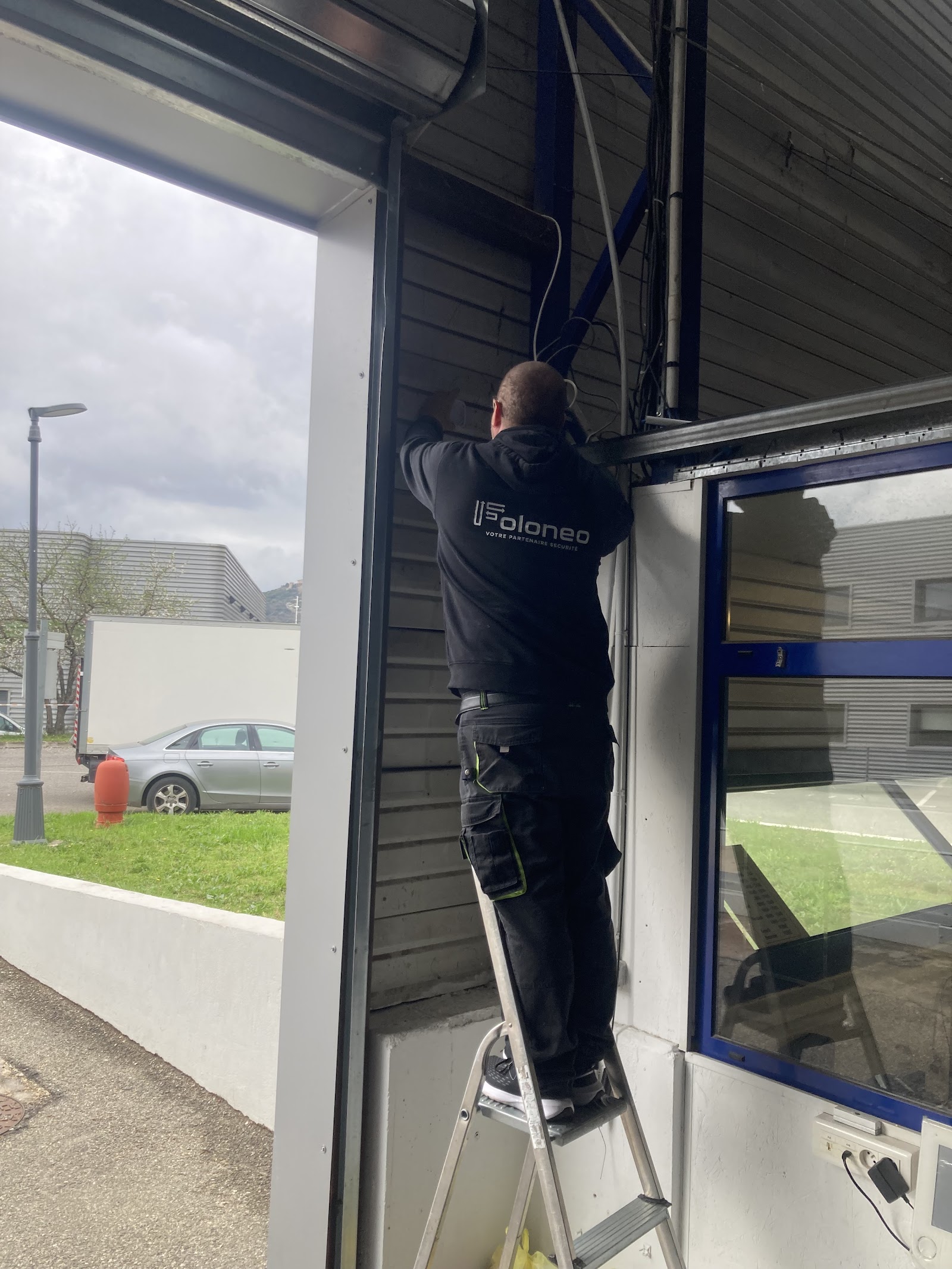 Technicien FOLONEO installant un système de sécurité dans un local professionnel